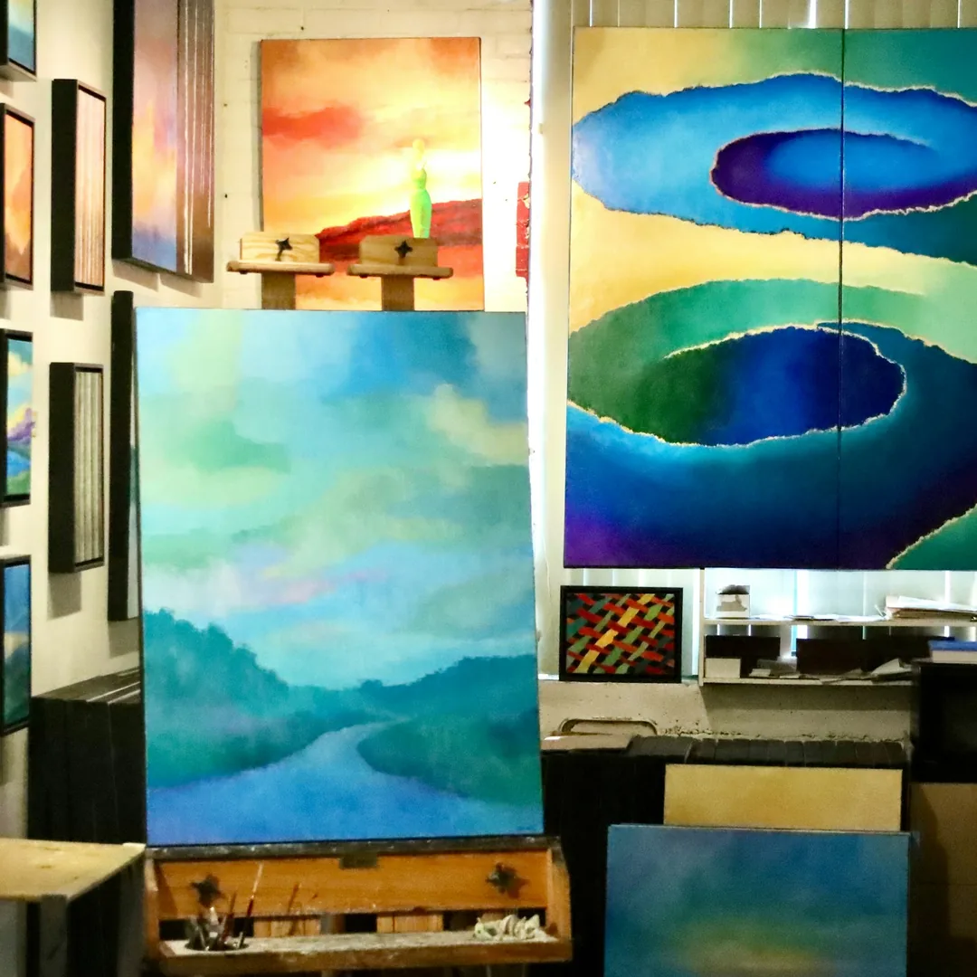Taller de pintura con un lienzo sobre el caballete y otras telas apoyadas en la pared